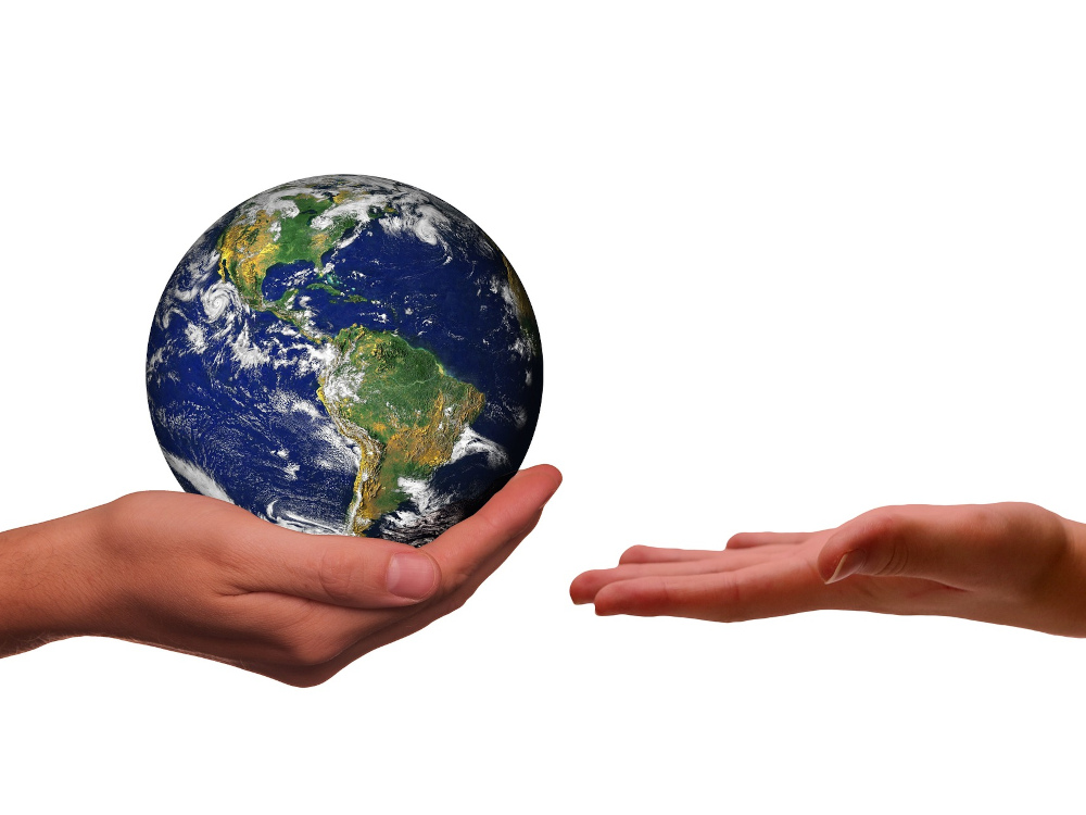 uma mão a segurar o planeta terra e outra esticada a tentar recebê-lo