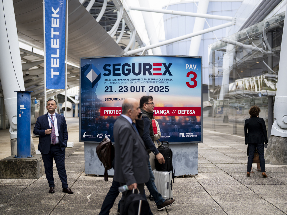 cartaz da segurex na FIL com pessoas a dirigirem-se à entrada